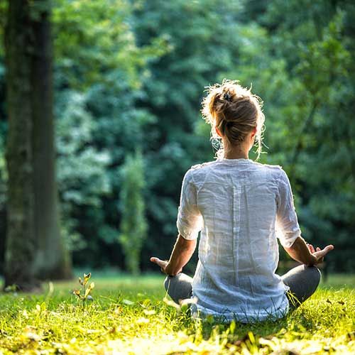 Frau meditiert und praktiziert Yoga im Wald