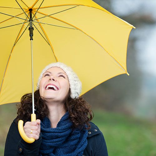 lachende frau mit Regenschirm